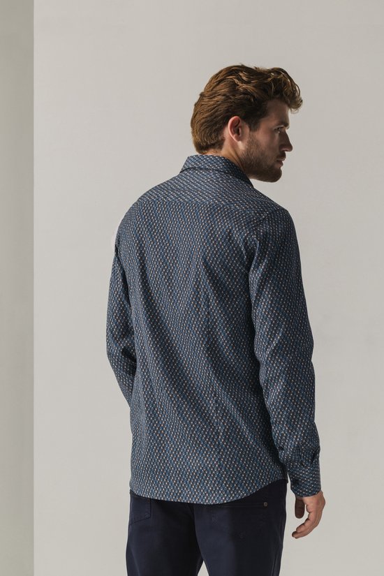 Achteraanzicht van een model in een donkerblauw overhemd met geometrische print.
