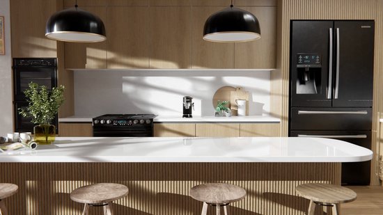 Une cuisine en bois avec des plans de travail blancs, des luminaires suspendus noirs, des appareils électroménagers et un réfrigérateur Samsung.