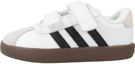 Witte sneaker met bruine zool, zwarte strepen en klittenbandsluiting. Grijze suède details bij de neus en hiel.