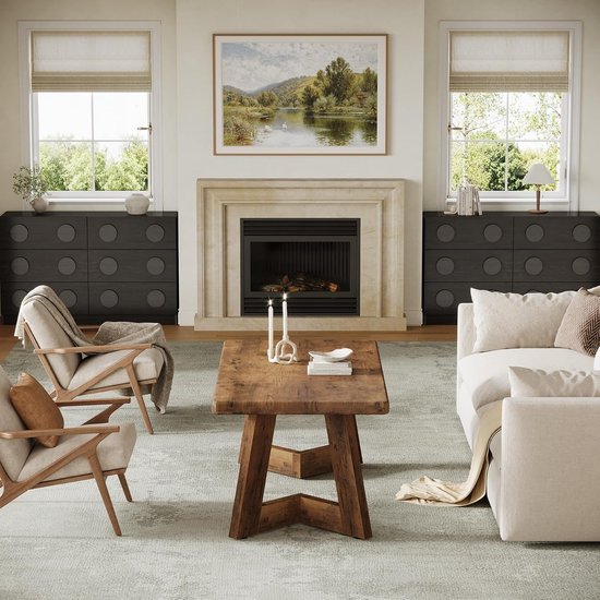 Bruine houten salontafel in een woonkamer met open haard, bank en twee fauteuils.