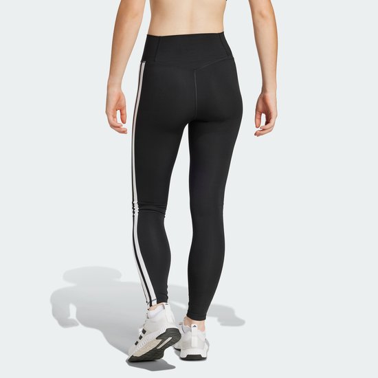 Zicht op de achterkant van een zwarte sportlegging met witte Adidas strepen op de zijkant.