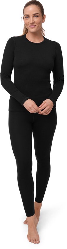 Vrouw in zwart thermoshirt met lange mouwen en legging, staand op witte achtergrond.