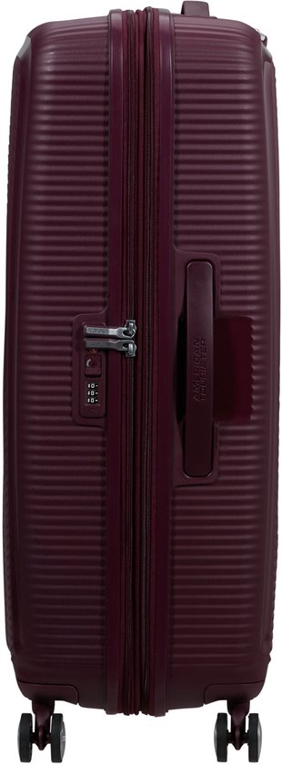 Burgondische koffer met ritssluiting, handvat, TSA-slot en vier wielen. Gekarteld design met 'American Tourister' tekst.