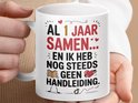 Witte mok met tekst 'AL 1 JAAR SAMEN...' en illustratie, vastgehouden door handen.