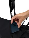 Hand plaatst smartphone in zijvak van Vaude rugzak.