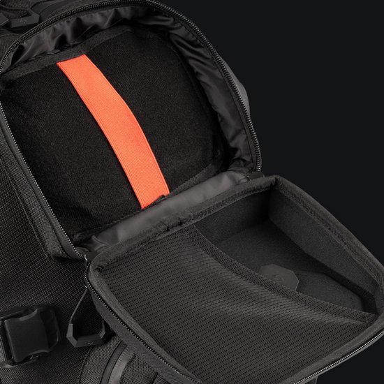 Open vak van een zwarte rugzak met oranje band en mesh binnenzak.