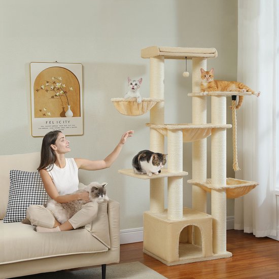 Een beige krabpaal met meerdere verdiepingen, met vijf katten op verschillende niveaus, waaronder een vrouw die een kat vasthoudt.