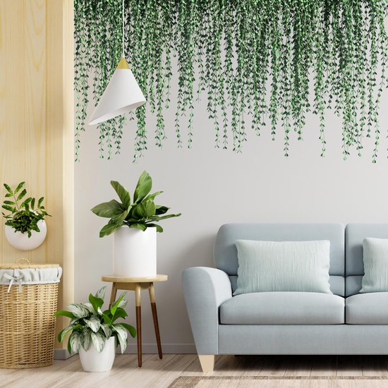 Wanddecoratie met hangende groene planten, boven een blauwe bank