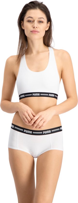 Model in wit Puma sportbh topje en bijpassende short, beide met zwarte Puma band.
