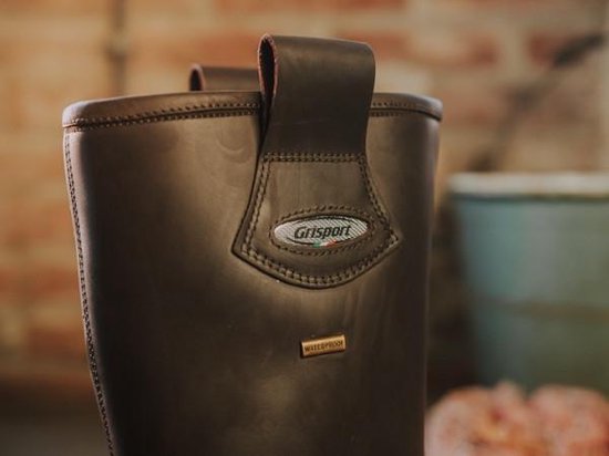 Detail van de bovenkant van een bruine leren werklaars met 'Grisport' en 'waterproof' logo.
