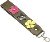 Een fleurige en vrolijke kunstleren sleutelhanger-tassenhanger die ook gebruikt kan worden aan de portemonnee of sleutelbos. De binnenkant heeft een leuke print en de buitenkant is