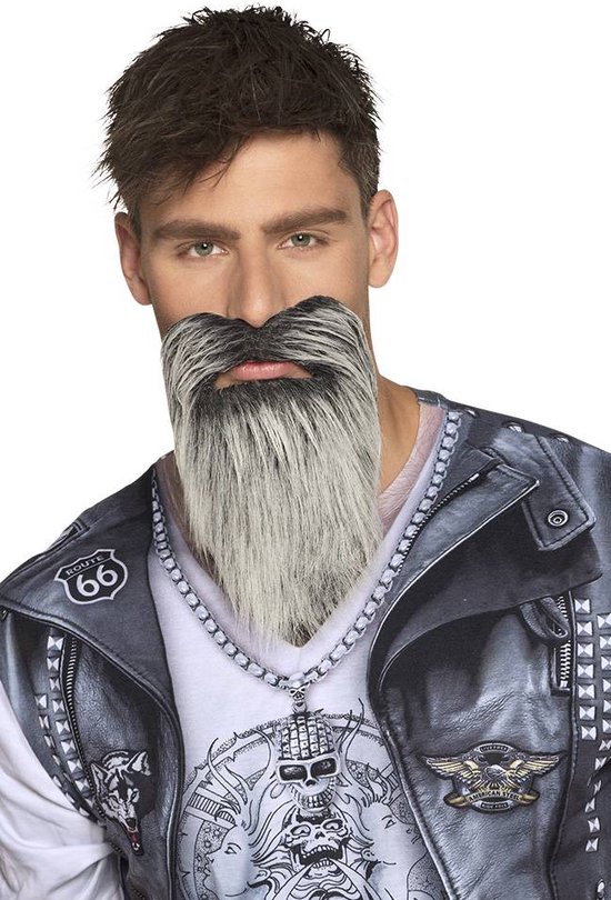 Man avec barbe et moustache grises et noires, portant une veste en cuir avec chaîne et un t-shirt imprimé tête de mort.
