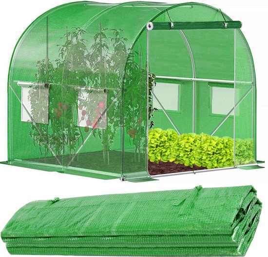 Groene tunnelkas met metalen frame, gevuld met tomatenplanten en sla. Roldeken ligt onder de kas.