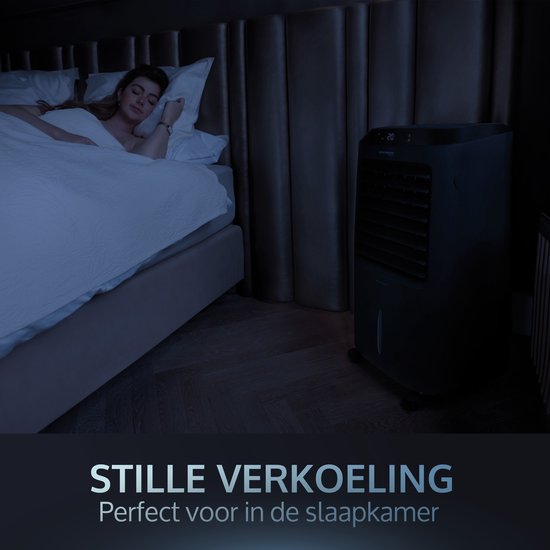 Zwarte mobiele aircooler naast een bed met een slapende vrouw, stille werking voor de slaapkamer.