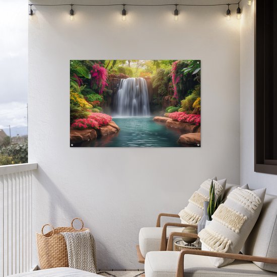 Une affiche d'une cascade dans une jungle avec des fleurs roses et de l'eau bleue, accrochée à un mur extérieur blanc sur un balcon.