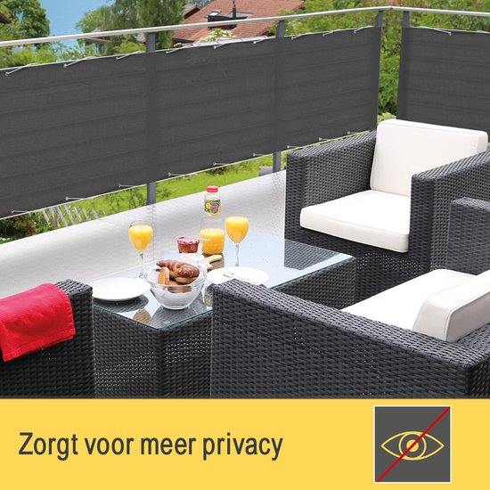 Donkergrijs balkondoek op een balkon met tuinmeubelen en een tafel met drankjes en gebak. "Zorgt voor meer privacy".