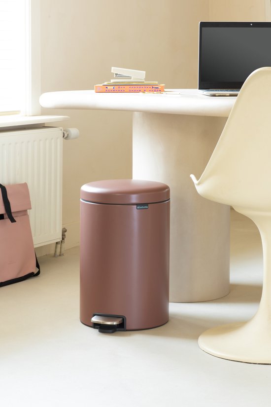 Bruine Brabantia NewIcon prullenbak met metalen trapper, staand in een kantoorruimte.