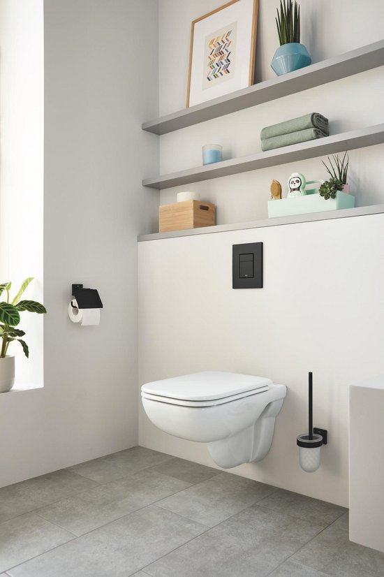 Een moderne badkamer met een wandcloset en een matzwarte toiletrolhouder met deksel naast een raam.