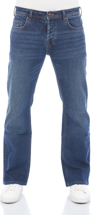Blauwe jeans met knoopsluiting, gedragen met witte sneakers.