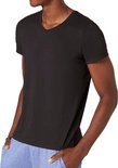 Man met zwart t-shirt met V-hals, korte mouwen, hands in zakken.
