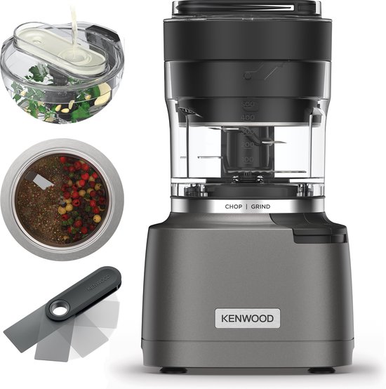 Grijze Kenwood chopper met toevoegingen, inclusief kruiden, peperkorrels en een spatel.