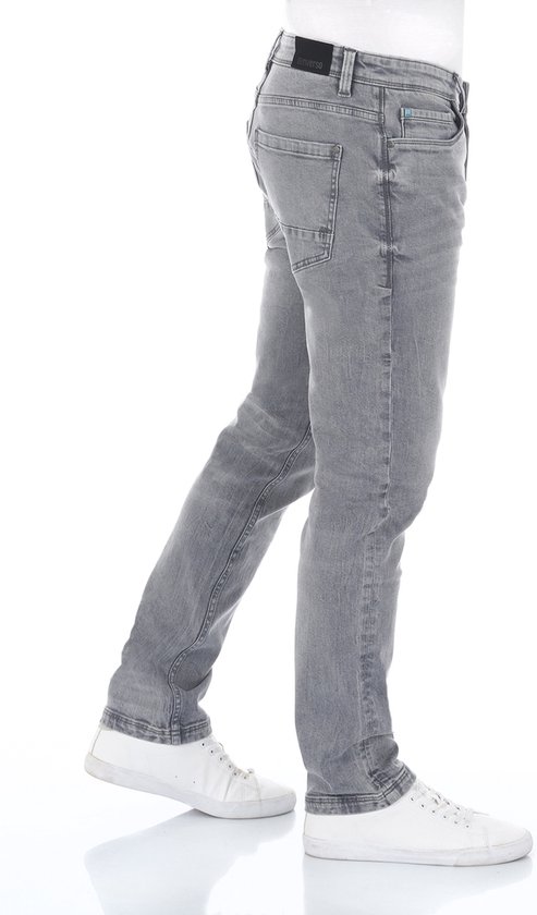 Model in grijze spijkerbroek, zijaanzicht.