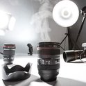 Zwarte cameralens beker met stoom, in een studio met camera's, lenzen en flitsers.