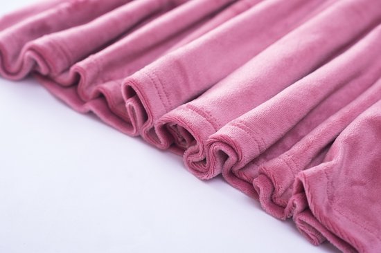 Gedetailleerde zoom van een roze jurk, met omgeslagen randen.