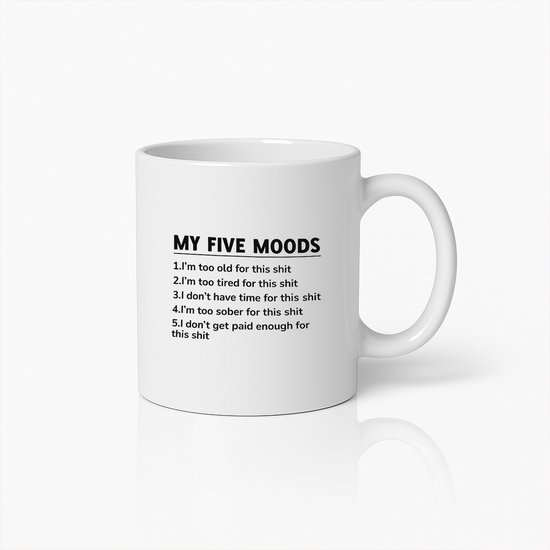 Tasse blanche avec le texte "MY FIVE MOODS" suivi de 5 déclarations humoristiques sur la fatigue et l'argent. La tasse repose sur une surface réfléchissante.