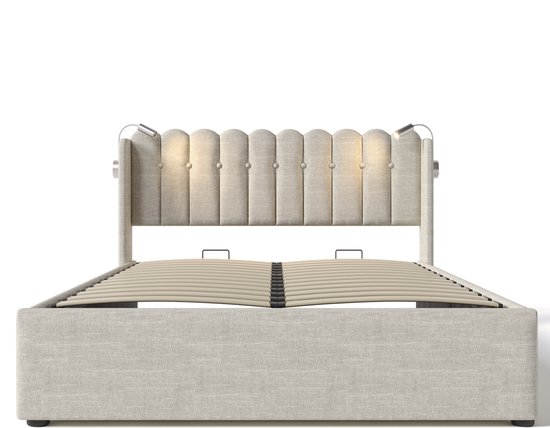 Beige gestoffeerd eenpersoonsbed met capitonné hoofdbord, voorzien van twee lampjes, zonder matras.