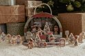 Houten adventskalender in de vorm van een treinstation met trein, figuurtjes en kerstbomen.