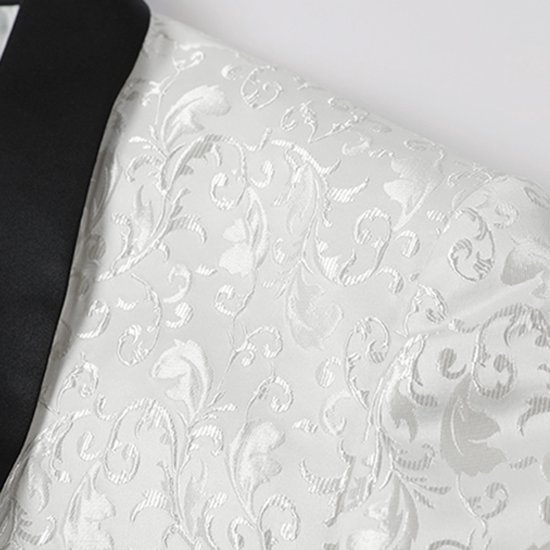 Detailopname van een wit jacquet met bloemenpatroon en zwarte reverskraag.