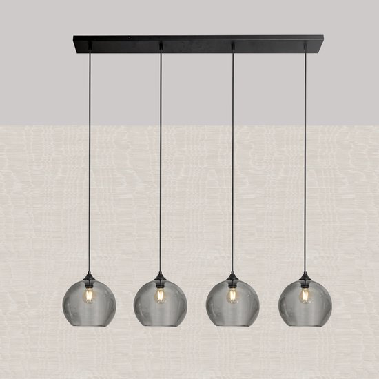 Hanglamp met vier rookkleurige glazen bollen aan een zwarte balk, tegen een lichtbeige achtergrond.