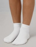 Voeten in witte Falke sneakersokken.