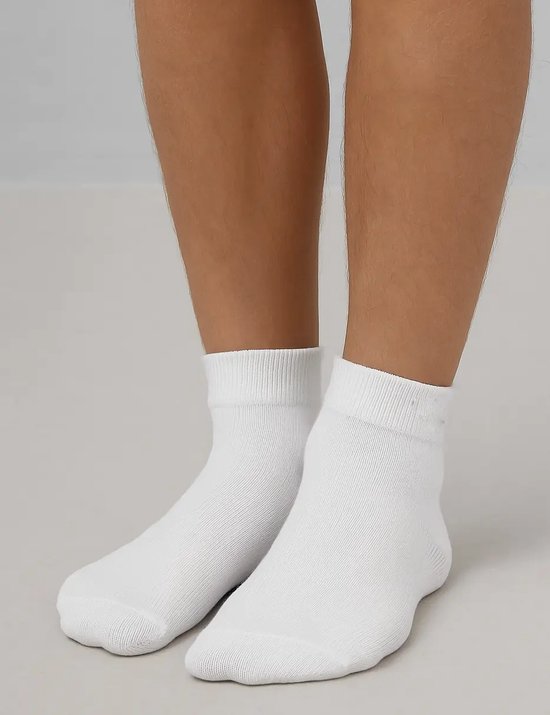 Voeten in witte Falke sneakersokken.