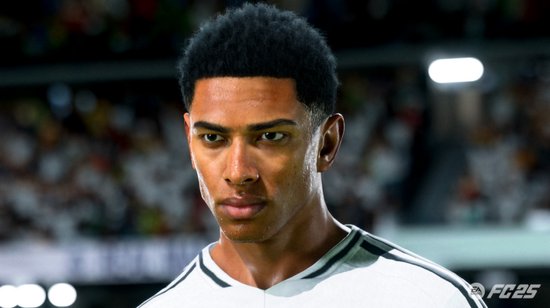 Close-up van een footballspeler met een donkere huidskleur en kort zwart haar, hij kijkt ernstig.