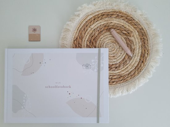 Wit schoolfotoboek met abstracte patronen in beige en groen, met een camera-icoon en elastische sluiting.