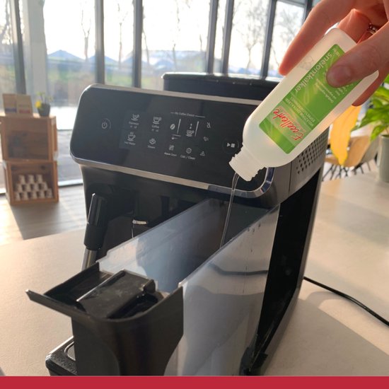 Hand giet Eccellente melkzuur ontkalker in een Philips koffiemachine.