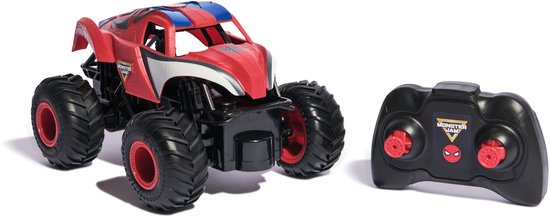 Monster truck rouge et bleu télécommandé avec de grandes roues noires et jantes rouges, à côté d'une manette noire avec boutons rouges.