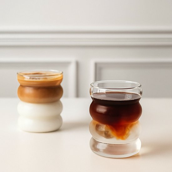 Ensemble de 2 verres au design bullé, remplis de café et de lait.