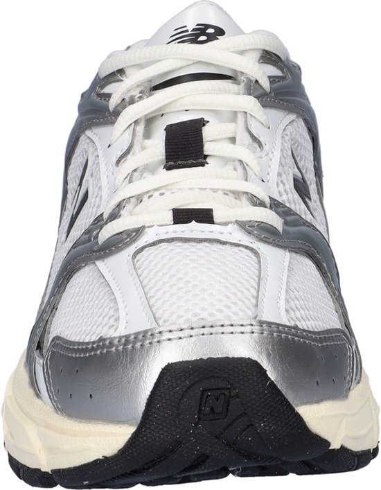 Voorkant van witte New Balance 530 sneakers met zilveren en zwarte accenten.