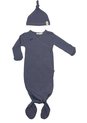 Een donkerblauwe knoopslaapzak met stipjes en een bijpassend babymutsje met knoop, plat gelegd op een witte achtergrond.