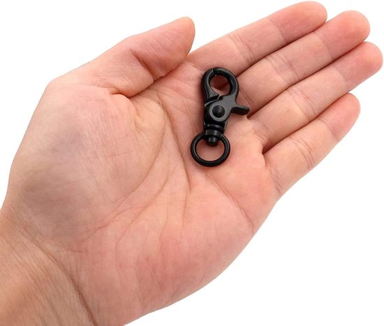 Zwarte draaibare karabijnhaak met een ring, liggend in een handpalm.