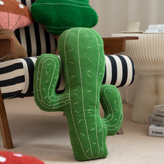 Groen, corduroy cactus kussen met witte stiksels, liggend op een stoel.