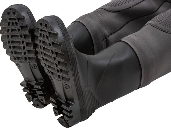 Detail van de profielzolen van de zwarte laarzen van het grijze neopreen waadpak.