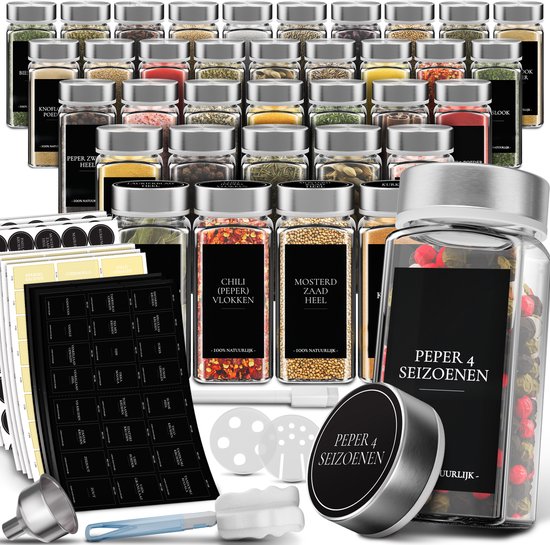 Collection de pots à épices en verre avec étiquettes noires, couvercles en acier inoxydable et divers accessoires tels que des autocollants et des entonnoirs.