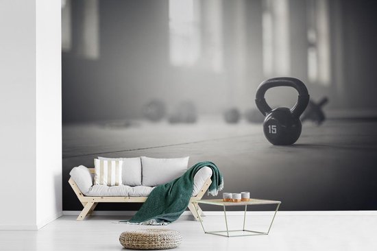 Behang - Fotobehang Verschillende kettlebellgewichten op de vloer in een  fitnessruimte... | bol