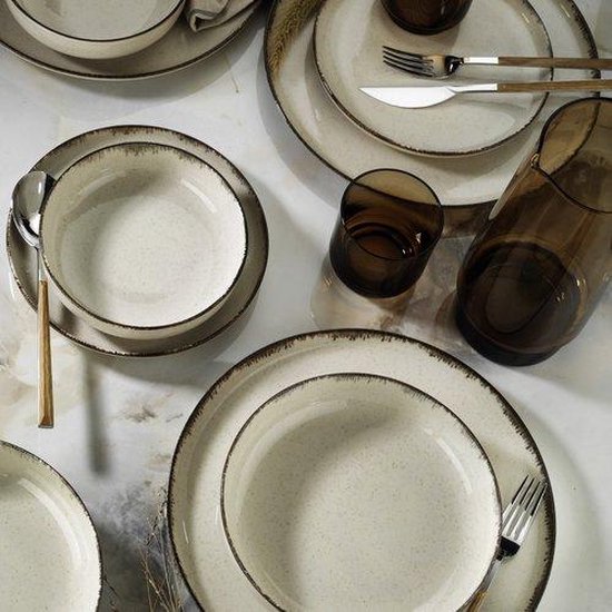 Gedekte tafel met beige aardewerken borden, kommen, glazen en bronzen vaas.