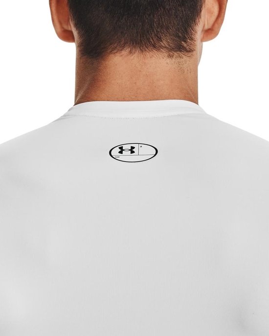 Achterkant nek van wit shirt met zwart Under Armour logo in ovale omlijsting.