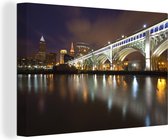 Canvas Schilderij Verlichte brug in de nacht bij het Amerikaanse Cleveland - 90x60 cm - Wanddecoratie